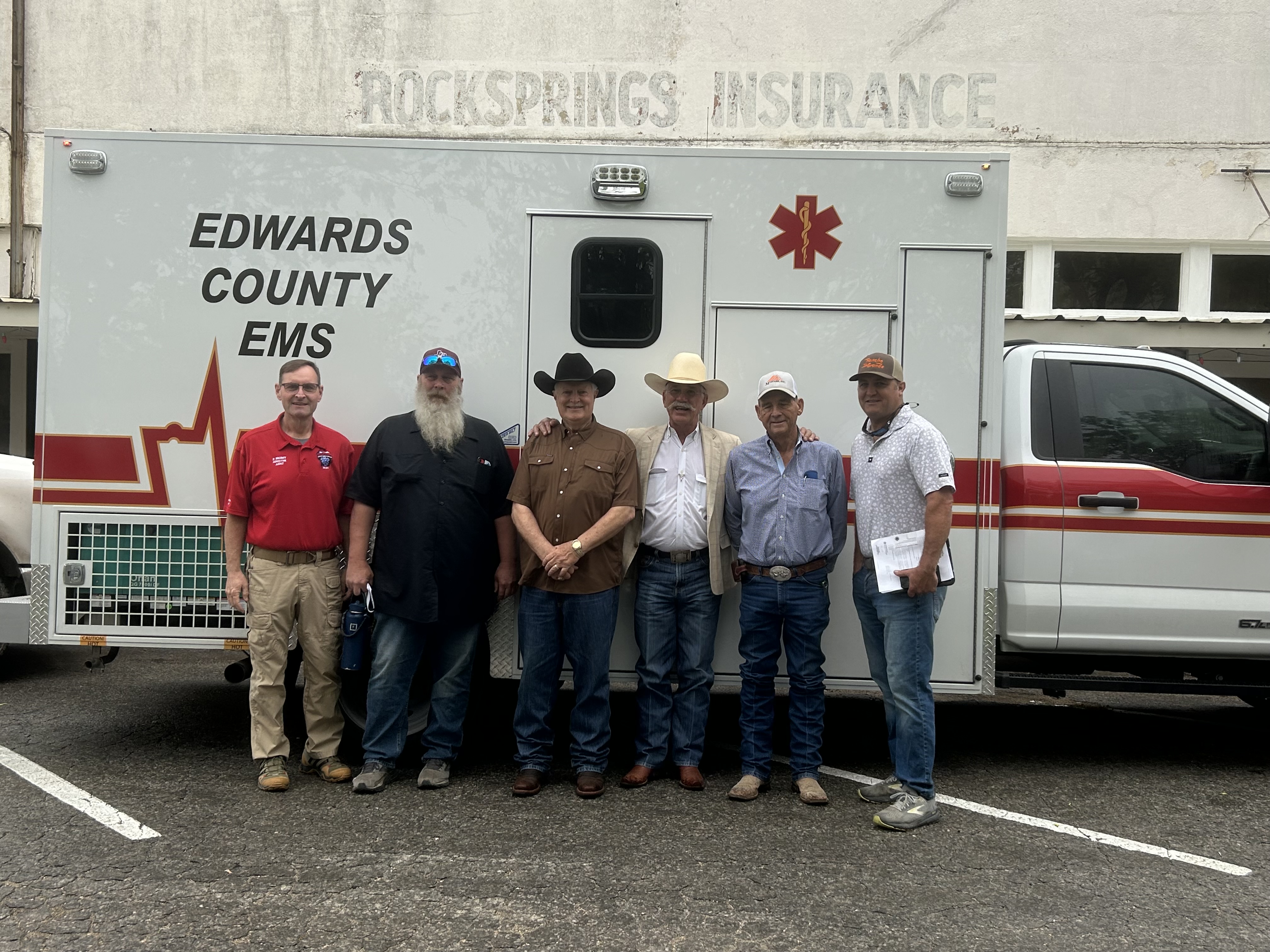 Souli standing with members of the EMS team in front of an Edwards County ambulance